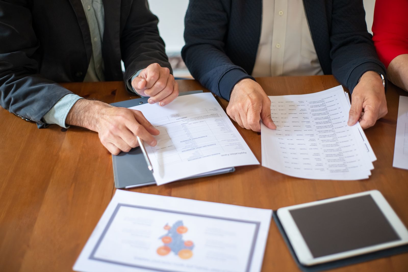 Profissionais revisando documentos e relatórios de auditoria
